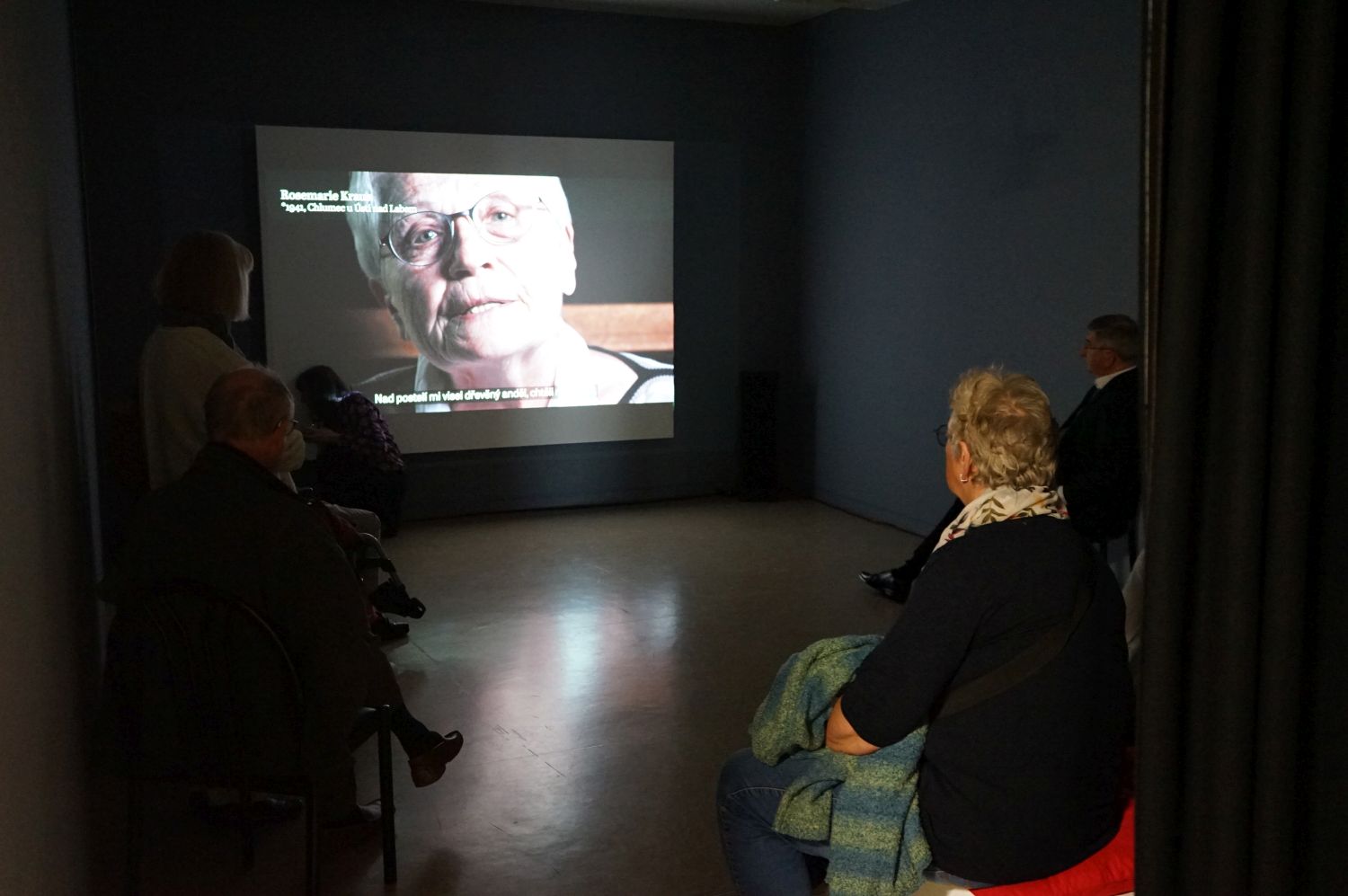 Besucherinnen und Besucher schauen das Zeitzeugenvideo